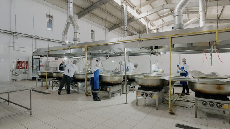 Bone ve önlükleriyle üretim salonunda çalışan mutfak ekibimiz