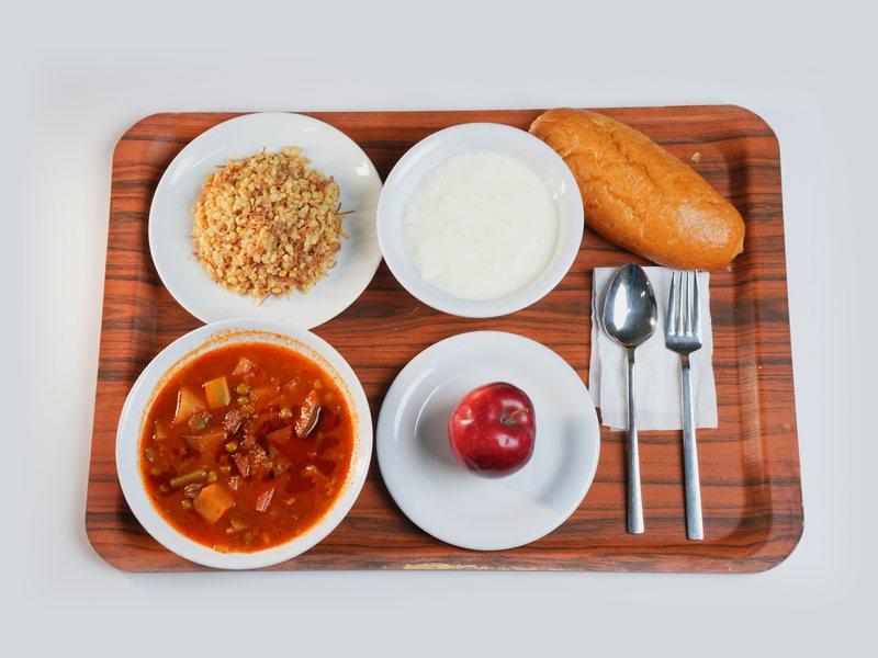Tepside çorba, bulgur pilavı, yoğurt, ekmek ve elmadan oluşan bir günlük tabldot menüsü